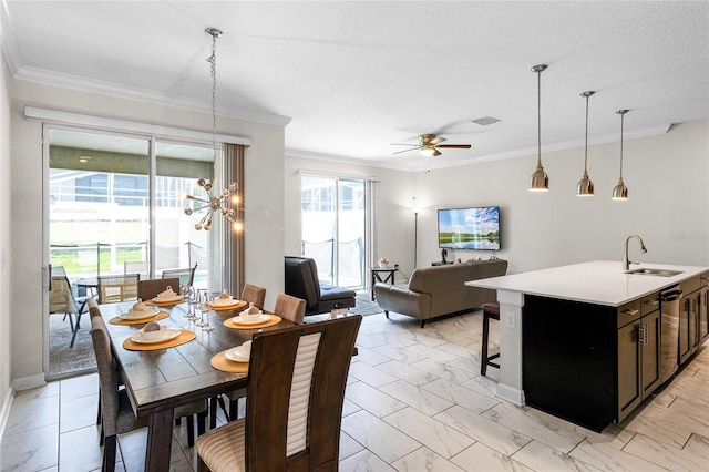 dining space featuring a textured ceiling, crown molding, sink, and ceiling fan with notable chandelier