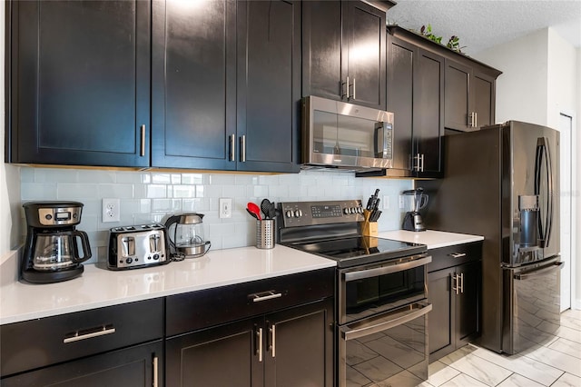 kitchen featuring backsplash, stainless steel appliances, and a textured ceiling