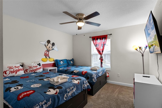 carpeted bedroom featuring ceiling fan and a textured ceiling