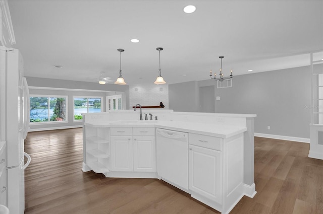 kitchen featuring white cabinets, white appliances, a kitchen island with sink, and sink