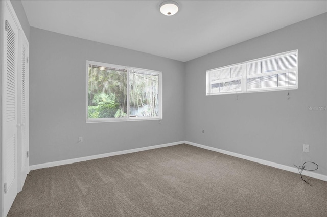 unfurnished bedroom featuring carpet floors and baseboards