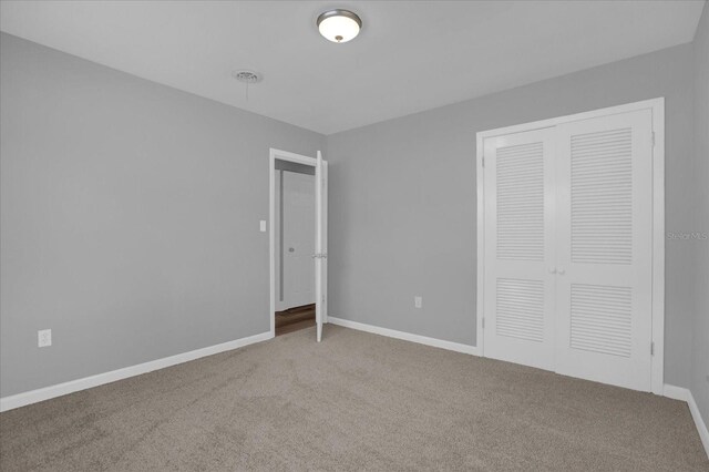 unfurnished bedroom featuring carpet floors, baseboards, and a closet