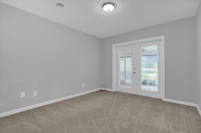 carpeted spare room with visible vents and baseboards