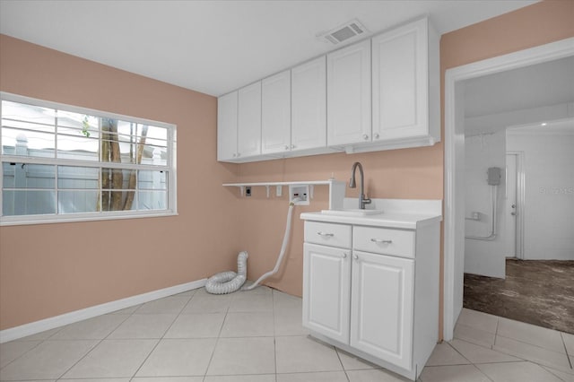 laundry room featuring hookup for an electric dryer, washer hookup, cabinets, sink, and light tile patterned flooring