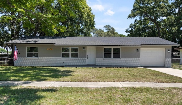 ranch-style house with brick siding, an attached garage, driveway, and a front lawn