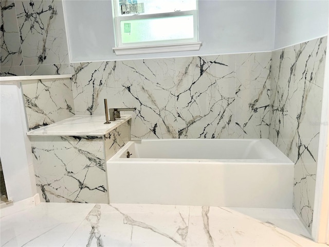 bathroom featuring tile walls and a washtub