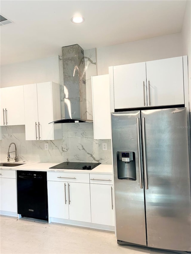 kitchen with white cabinets, sink, black appliances, wall chimney exhaust hood, and decorative backsplash