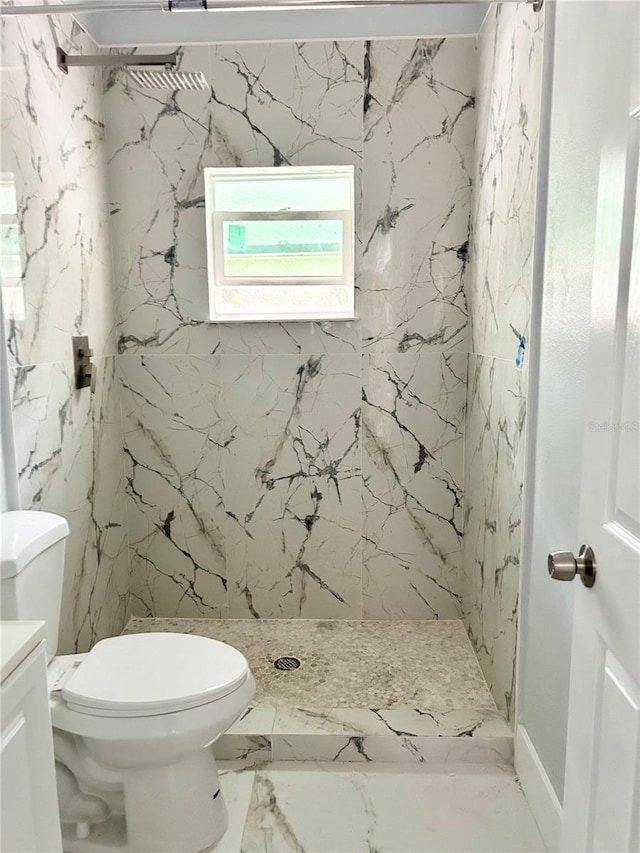 bathroom with vanity, toilet, and tiled shower