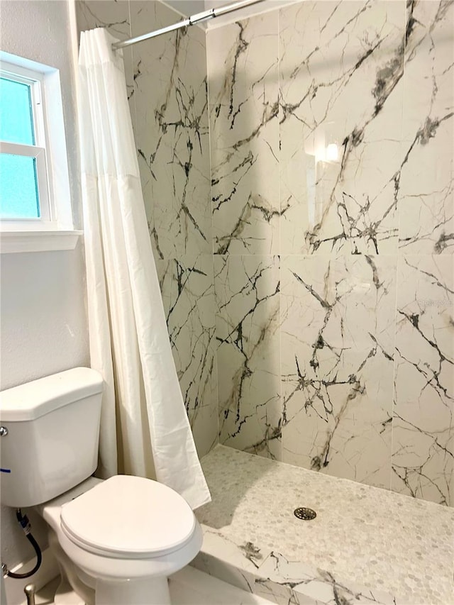 bathroom featuring curtained shower and toilet