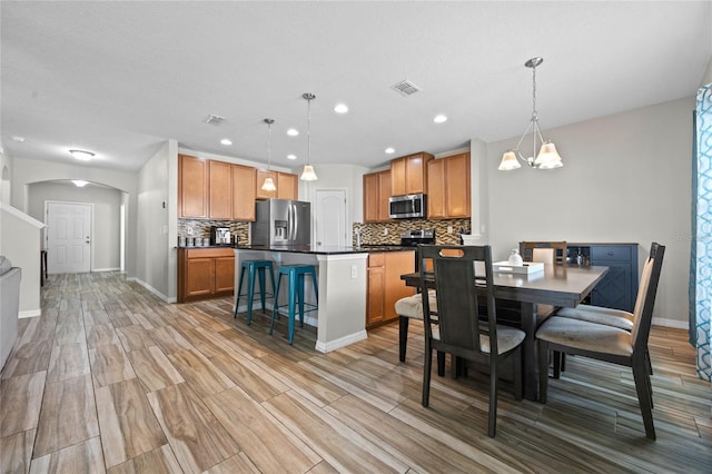 dining room featuring a notable chandelier, light hardwood / wood-style floors, and a textured ceiling