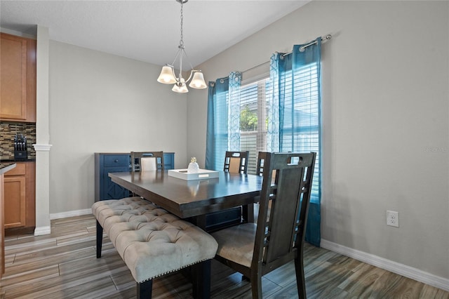 dining room with light wood-type flooring and an inviting chandelier