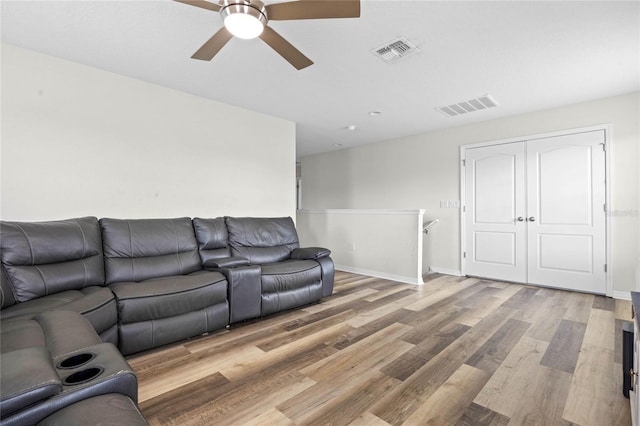 living room featuring light hardwood / wood-style floors and ceiling fan