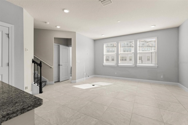 unfurnished room with a textured ceiling