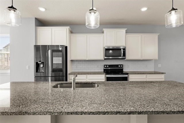 kitchen with tasteful backsplash, hanging light fixtures, stainless steel appliances, sink, and dark stone counters