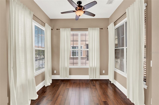 empty room with ceiling fan and dark hardwood / wood-style floors