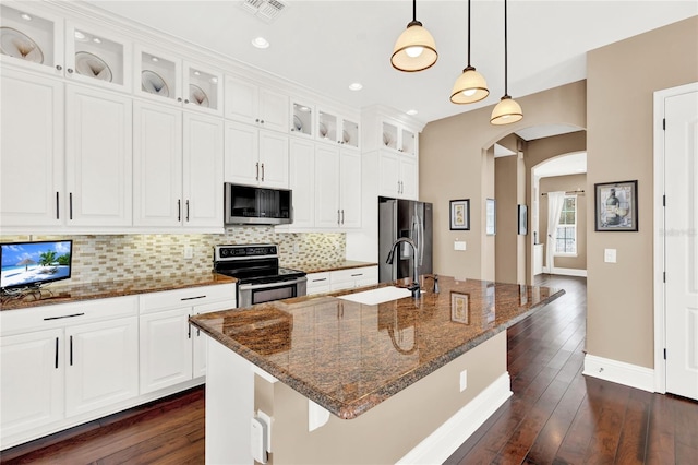 kitchen with a kitchen island with sink, backsplash, stainless steel appliances, sink, and dark hardwood / wood-style floors