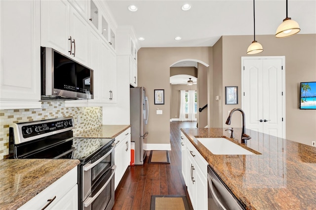 kitchen featuring dark hardwood / wood-style floors, pendant lighting, backsplash, appliances with stainless steel finishes, and sink