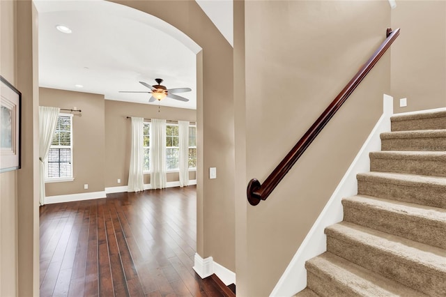 stairs with wood-type flooring and ceiling fan