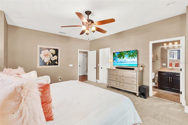 bedroom featuring ceiling fan, connected bathroom, and light carpet