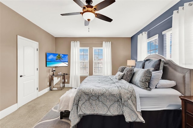 bedroom featuring multiple windows, ceiling fan, and light colored carpet