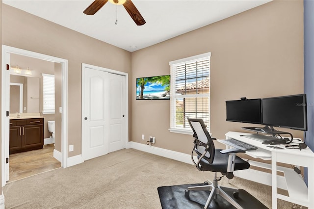 office space with ceiling fan and light carpet