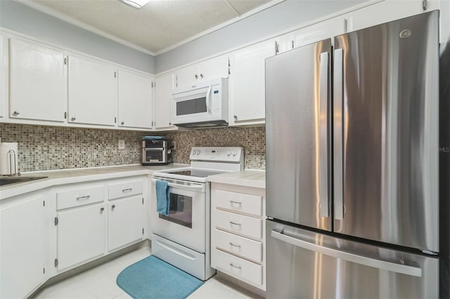 kitchen featuring light tile patterned floors, white appliances, white cabinetry, decorative backsplash, and ornamental molding