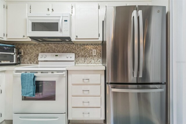 kitchen with white appliances, white cabinets, and decorative backsplash