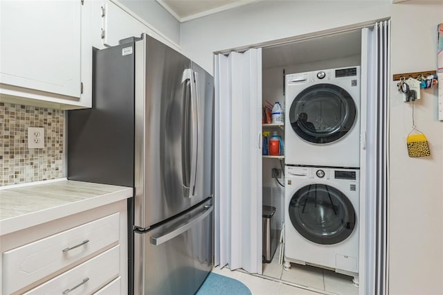 laundry room with light tile patterned floors and stacked washing maching and dryer