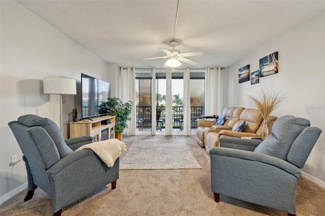 carpeted living room with a textured ceiling, expansive windows, and ceiling fan