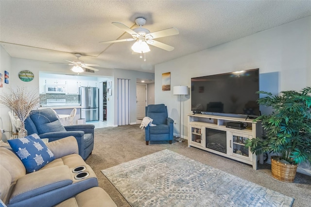 carpeted living room with ceiling fan and a textured ceiling