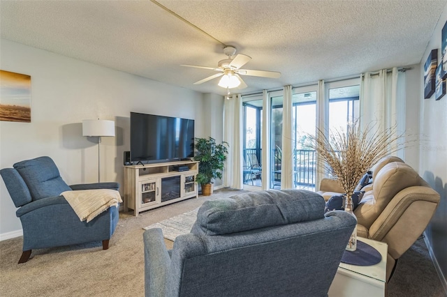 carpeted living room featuring ceiling fan and a textured ceiling