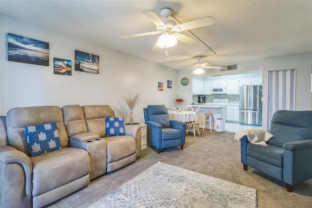 carpeted living room with a textured ceiling and ceiling fan