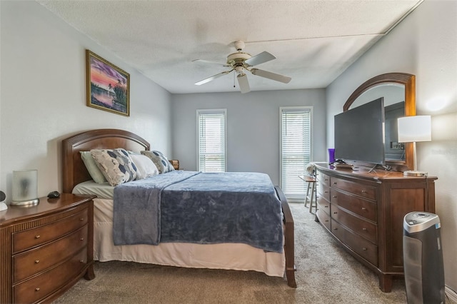 carpeted bedroom with a textured ceiling and ceiling fan