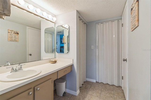 bathroom featuring a textured ceiling and vanity