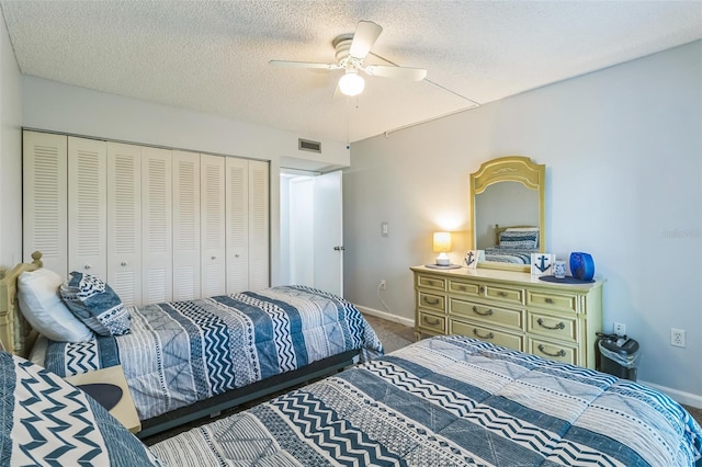 bedroom with carpet flooring, a textured ceiling, ceiling fan, and a closet