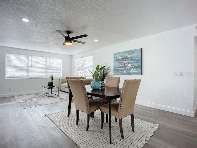 dining space with a textured ceiling, ceiling fan, and hardwood / wood-style floors