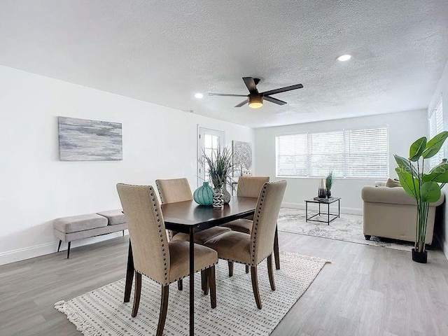 dining room with a textured ceiling, ceiling fan, and light hardwood / wood-style floors