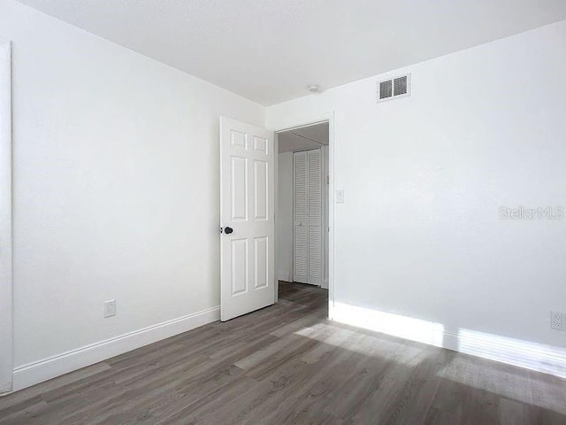 unfurnished room with dark wood-type flooring