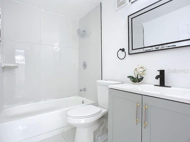 full bathroom featuring tiled shower / bath, vanity, toilet, and tile patterned floors