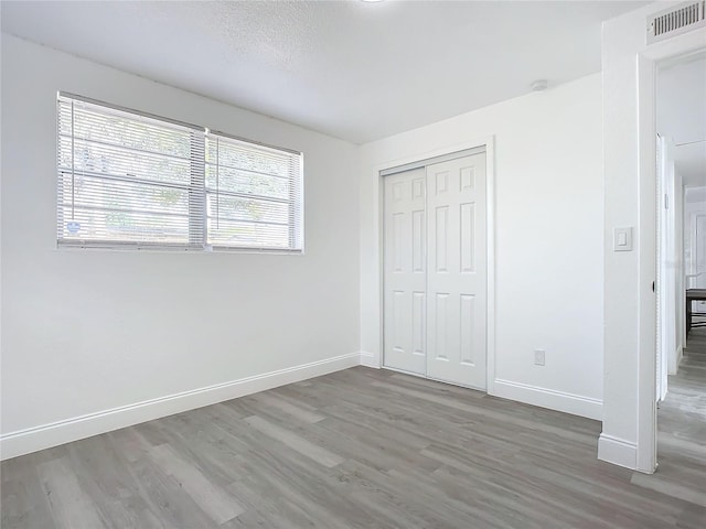 unfurnished bedroom featuring hardwood / wood-style floors and a closet