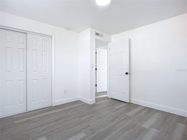 unfurnished bedroom with a closet and wood-type flooring