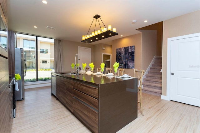 kitchen featuring light hardwood / wood-style floors, stainless steel appliances, a center island with sink, and sink