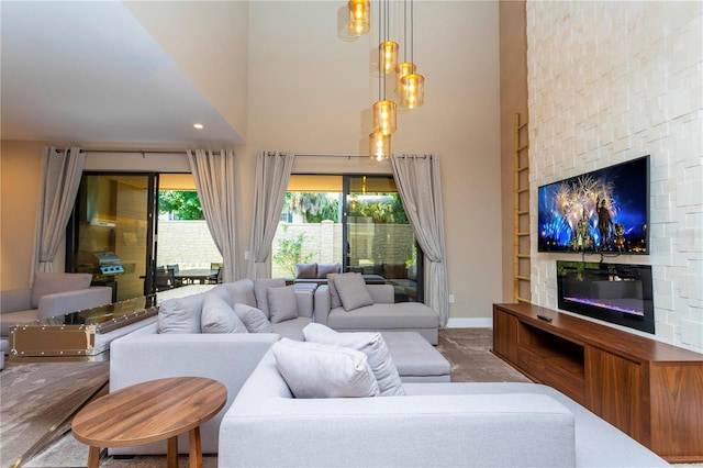 carpeted living room with a fireplace and a towering ceiling