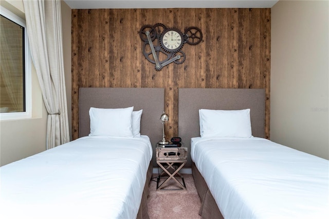 bedroom featuring carpet flooring and wooden walls