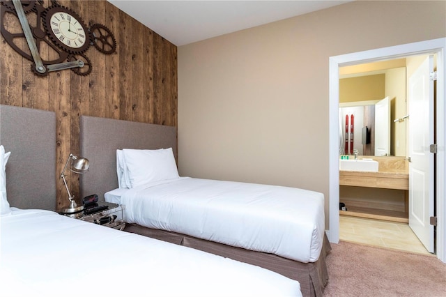 carpeted bedroom with ensuite bathroom and sink