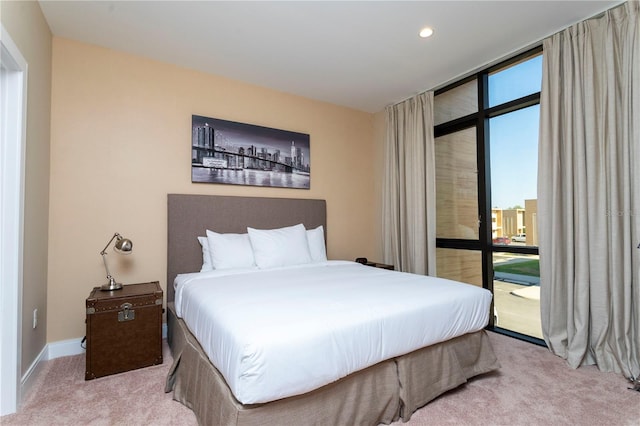 carpeted bedroom with multiple windows and a wall of windows