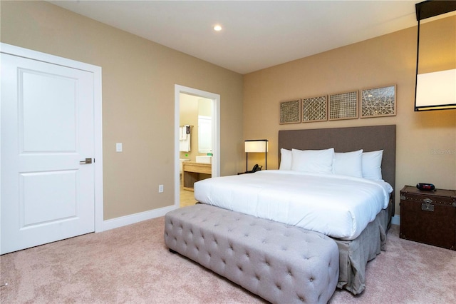 bedroom with light colored carpet and ensuite bath