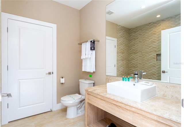 bathroom featuring tile patterned flooring, toilet, and vanity