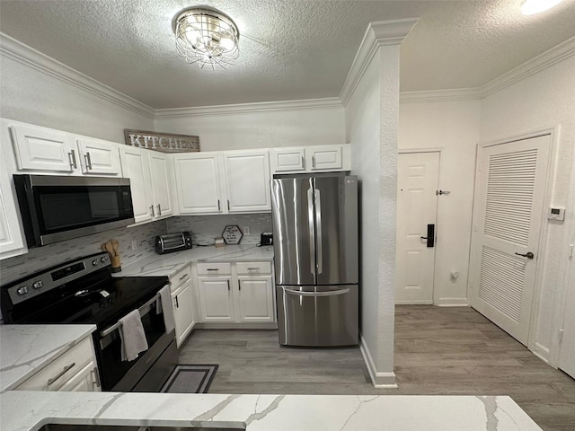 kitchen featuring light wood-type flooring, white cabinetry, stainless steel appliances, and a textured ceiling