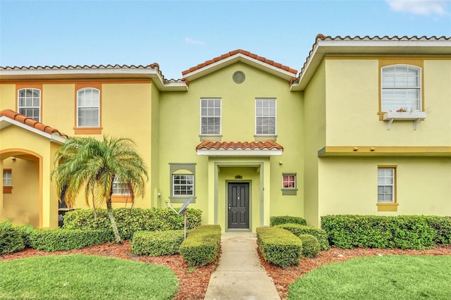 mediterranean / spanish-style house featuring a tile roof and stucco siding